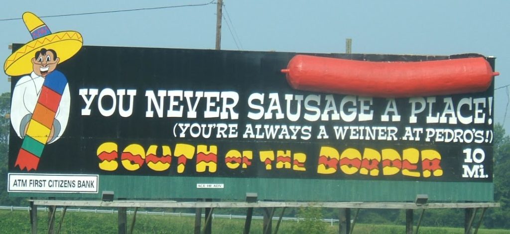 South Of The Border billboard reading you never sausage a place with an image of a big sausage on it