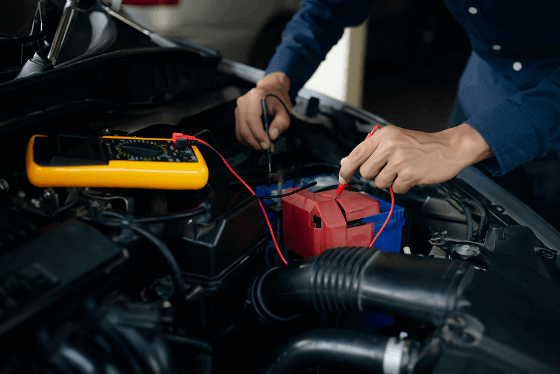 A technician at ABC Auto Repair in Houston, TX tests the battery terminals for voltage drop while performing electrical repairs on a Honda Accord