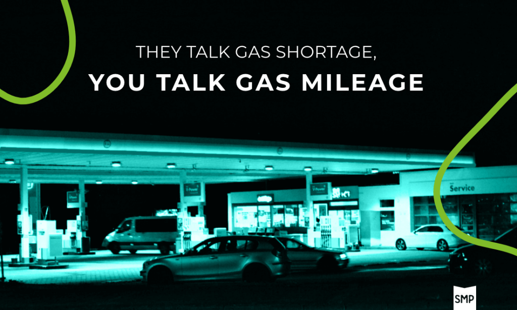 They Talk Gas Shortage You Talk Gas Mileage white text over lack overlay with gas station lit up in background with Shop Marketing Pros logo