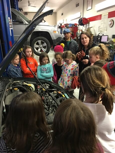 Girlington Garage hosts a car care clinic for a local girl scout troop.