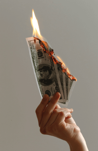 image of female hand holding up 4- 100 dollar bills that are on fire