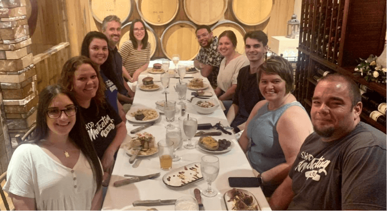 show your employees appreciation through a work dinner; Shop Marketing Pro owners Kim and Brian Walker pictured with 8 male and female employees around dinner table at Buddies in Hammond La