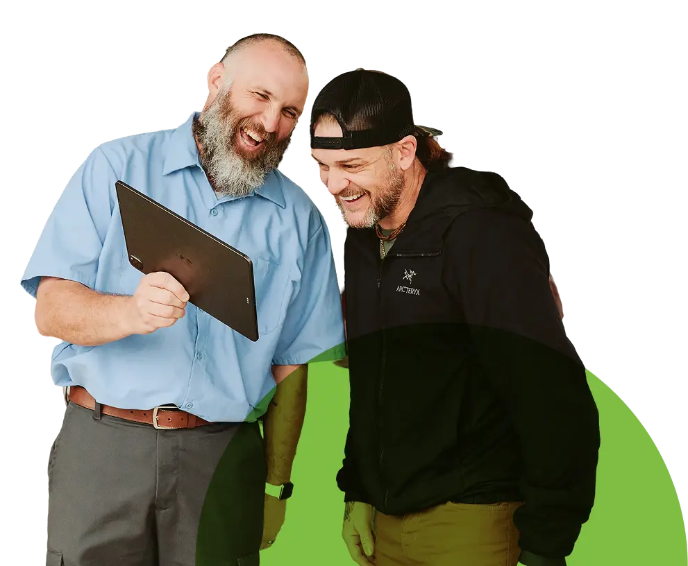 Two people standing together looking at a tablet.
